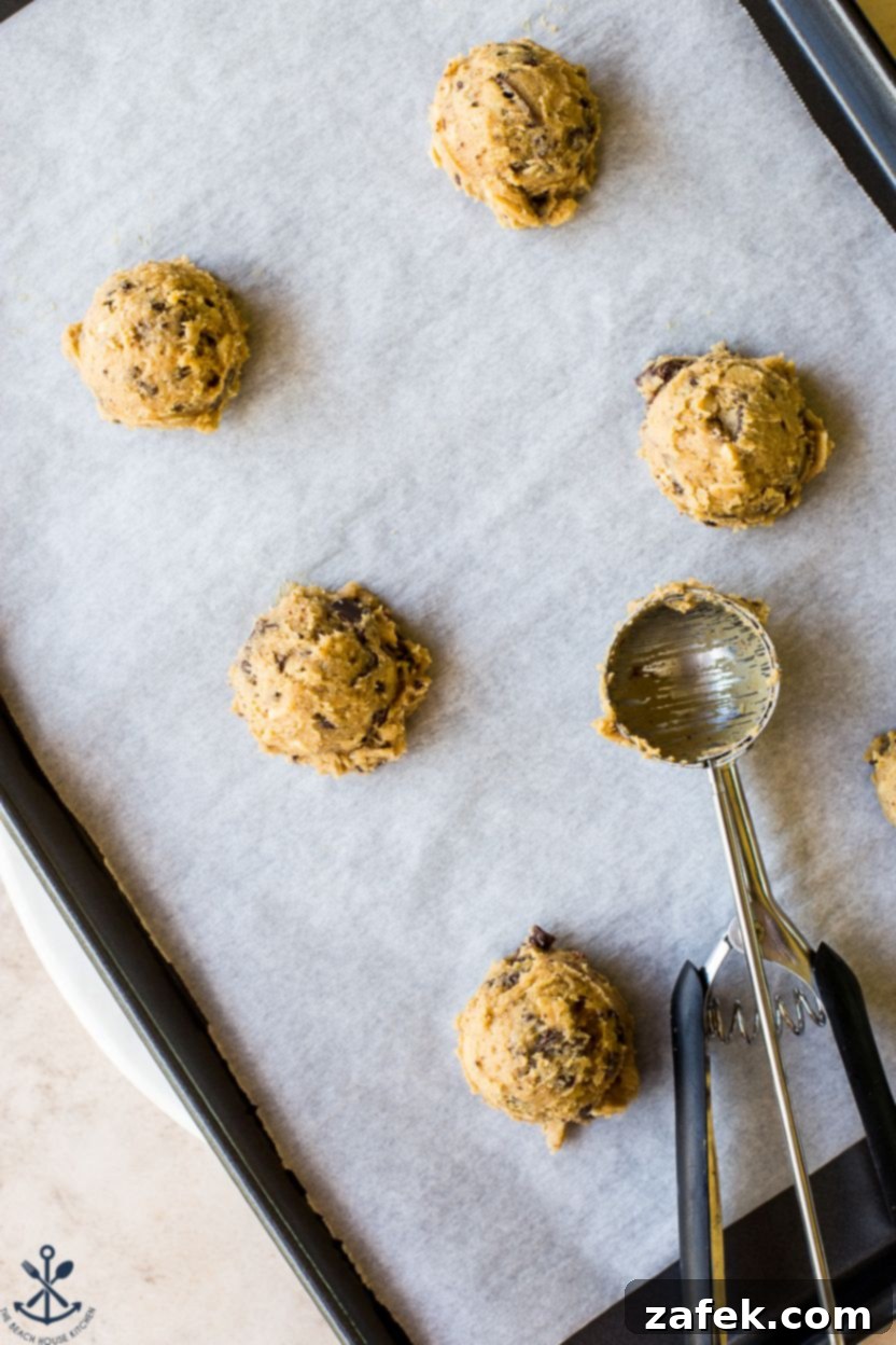 Coconut Almond Chocolate Chip Bliss Cookies 6 Overhead photo of scoops of cookie dough on a parchment-lined baking sheet
