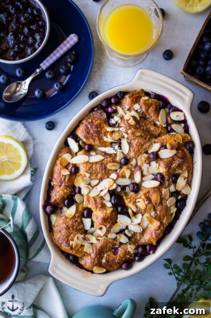Blueberry Croissant Bread Pudding with Blueberry Sauce Delicious Blueberry Croissant Bread Pudding in an oval baking dish, served with a side of homemade blueberry sauce, perfect for Easter brunch.