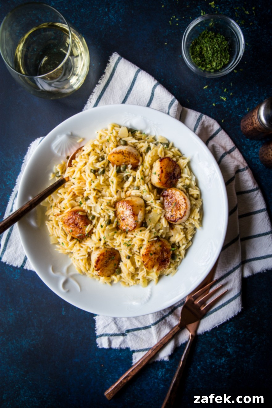 Pan-Seared Scallops with Zesty Orzo Piccata 3 Overhead photo of a white bowl filled with scallops and orzo