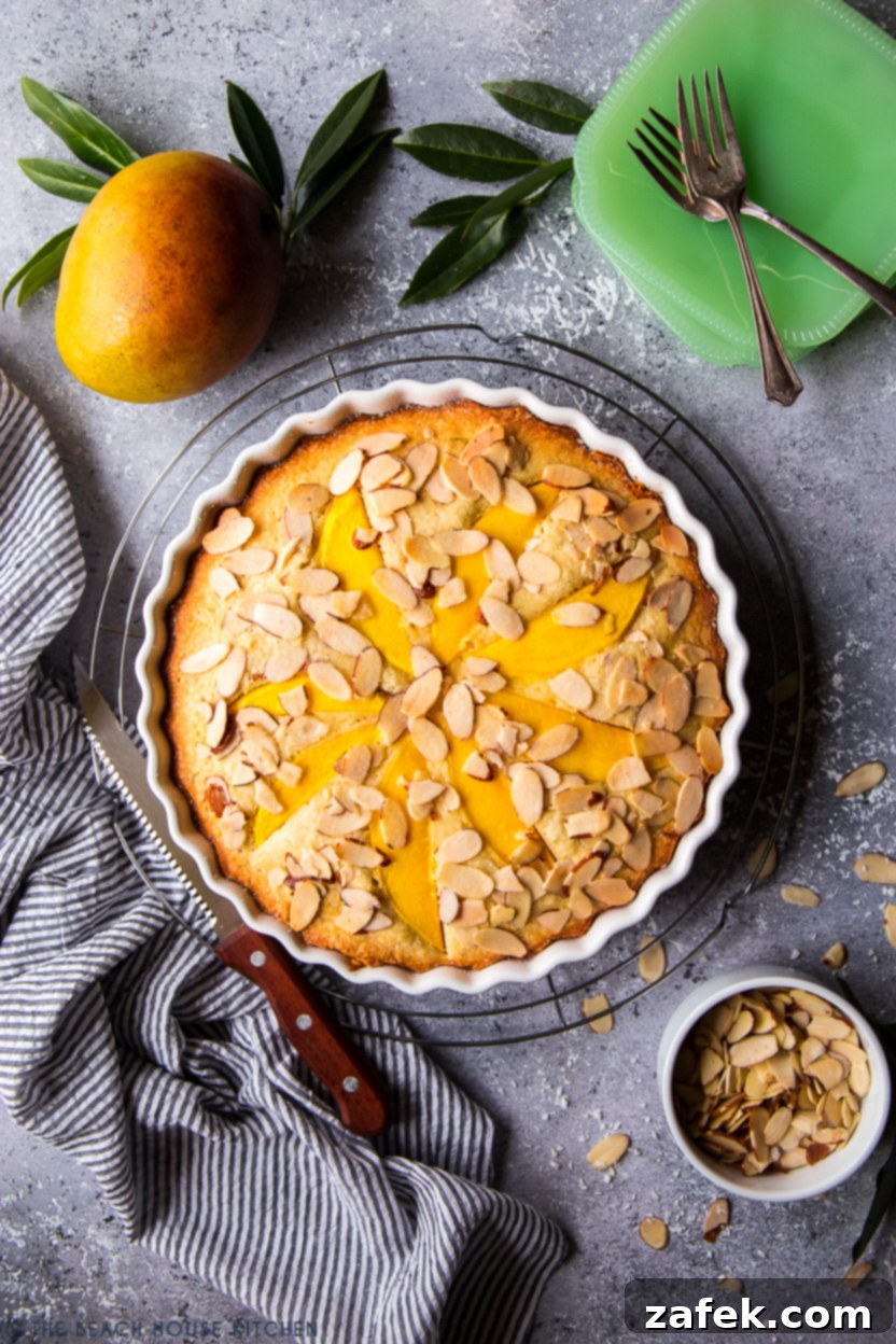 Overhead photo of a whole Tropical Mango Almond Cake, beautifully baked and ready to be served, highlighting its golden crust and fruit topping.