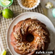 Overhead photo of key lime coconut bundt cake on a gold wire rack with a bowl of toasted coconut