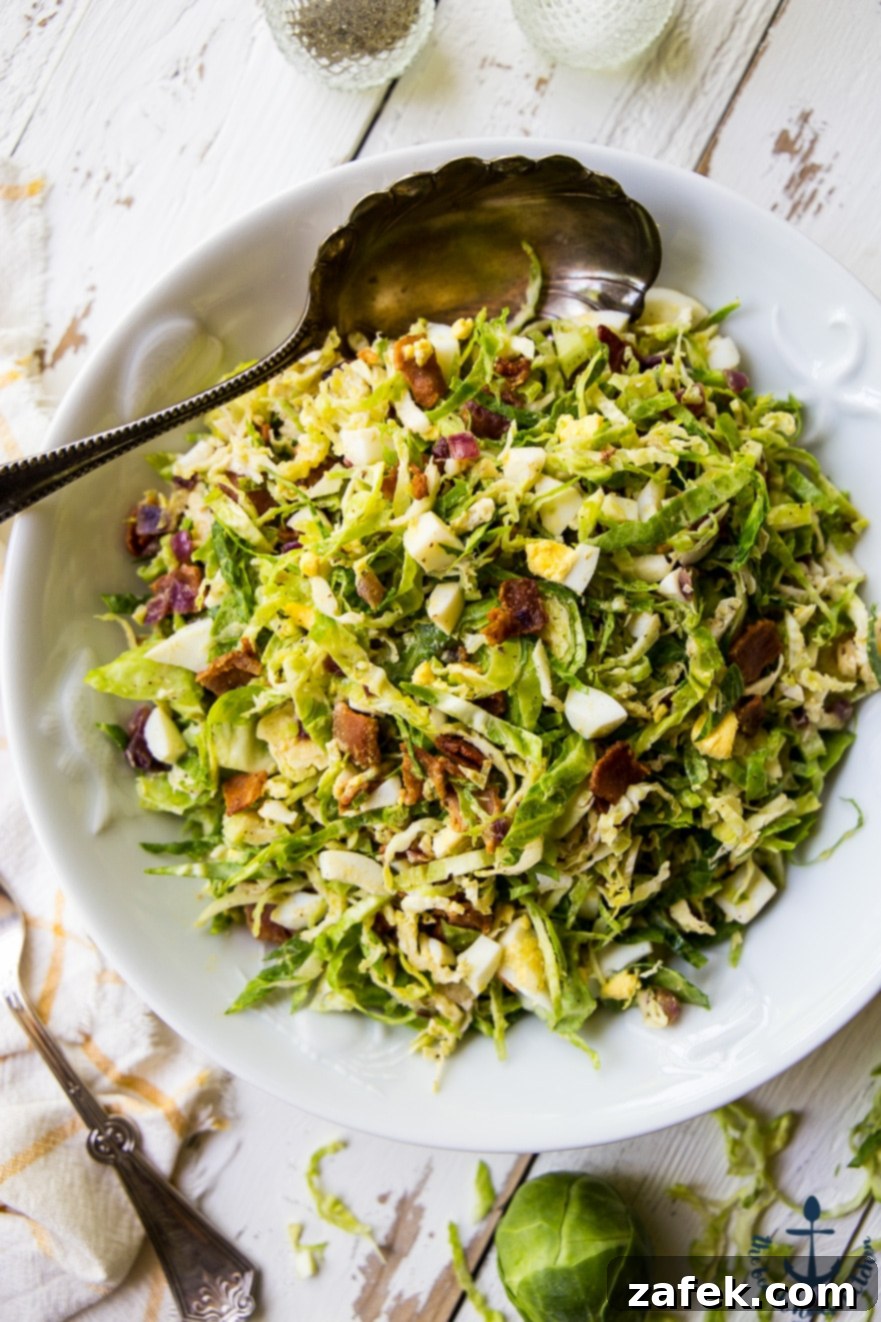 Shaved Brussels Sprouts Salad with Warm Bacon Dressing A bowl of Shaved Brussels Sprouts Salad ready to be served, showcasing the rich colors and textures of its ingredients.