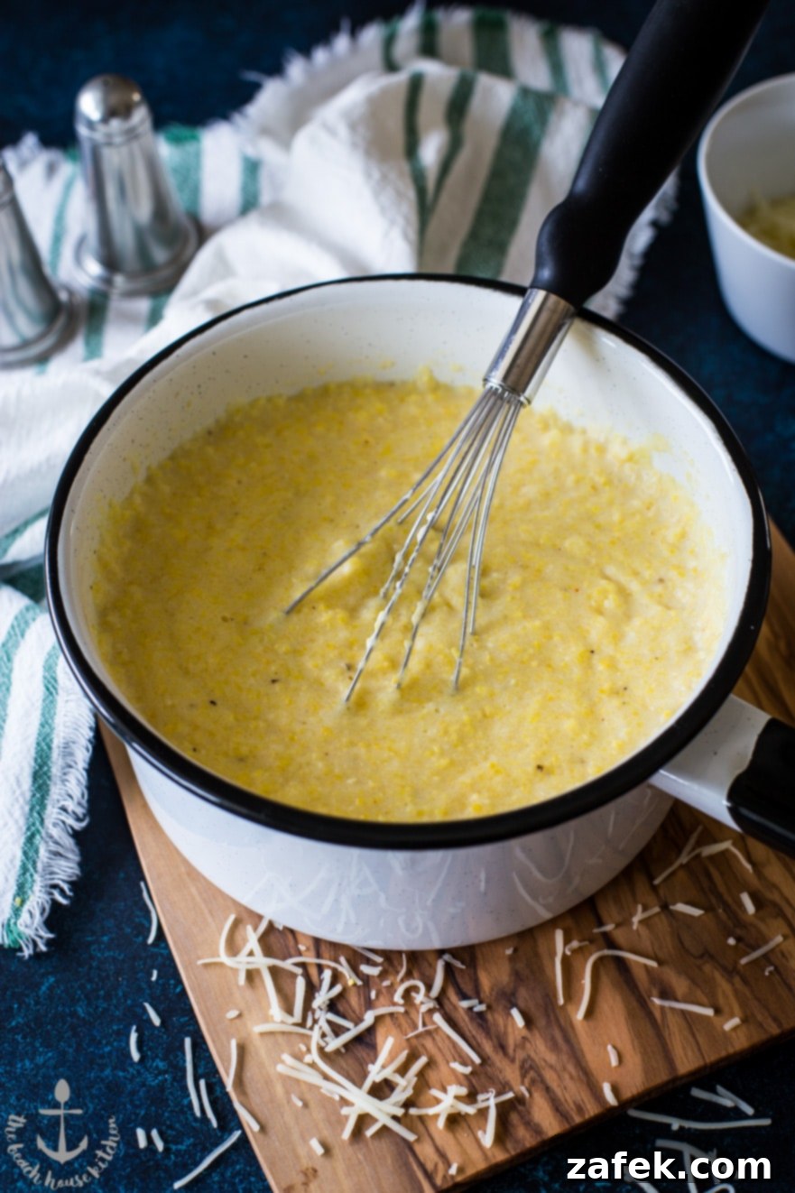 A serving of Cajun Scallops and Cheesy Grits, garnished with fresh parsley.