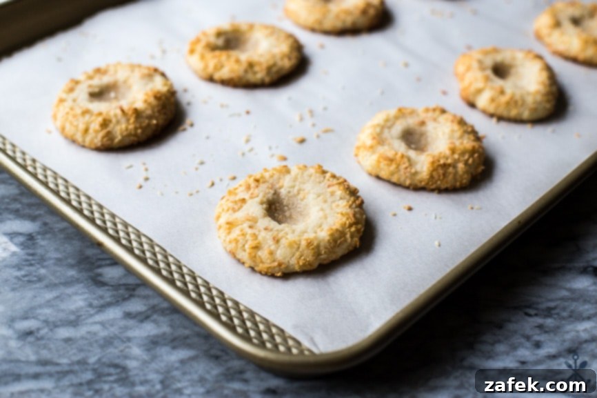 Creamy Coconut Thumbprint Bites 6 A baking sheet of pre-filled coconut thumbprint cookies