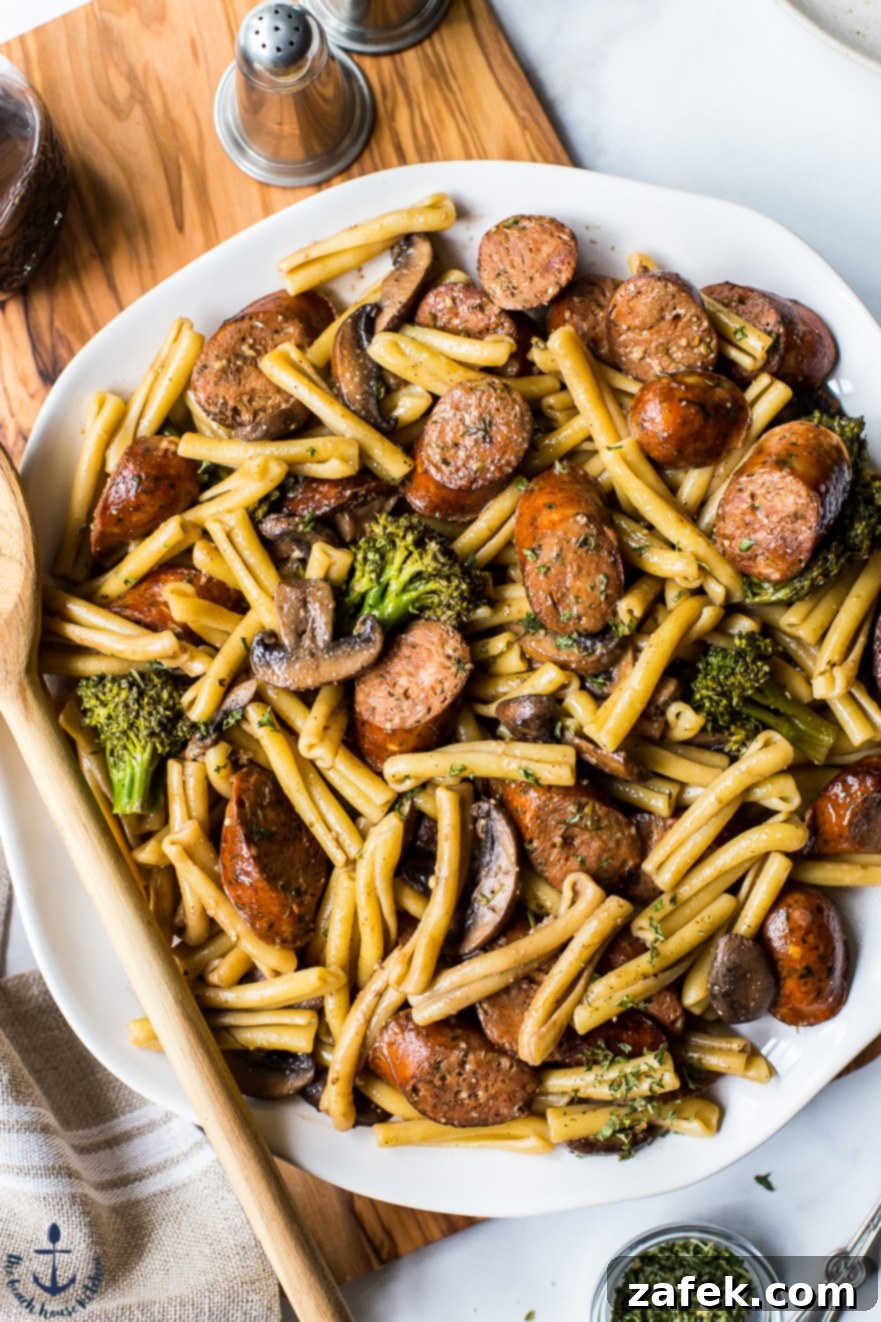 Up close overhead photo of a platter of Balsamic Pasta with Chicken Sausage, Broccoli and Mushrooms, showing the rich sauce and perfectly coated pasta.
