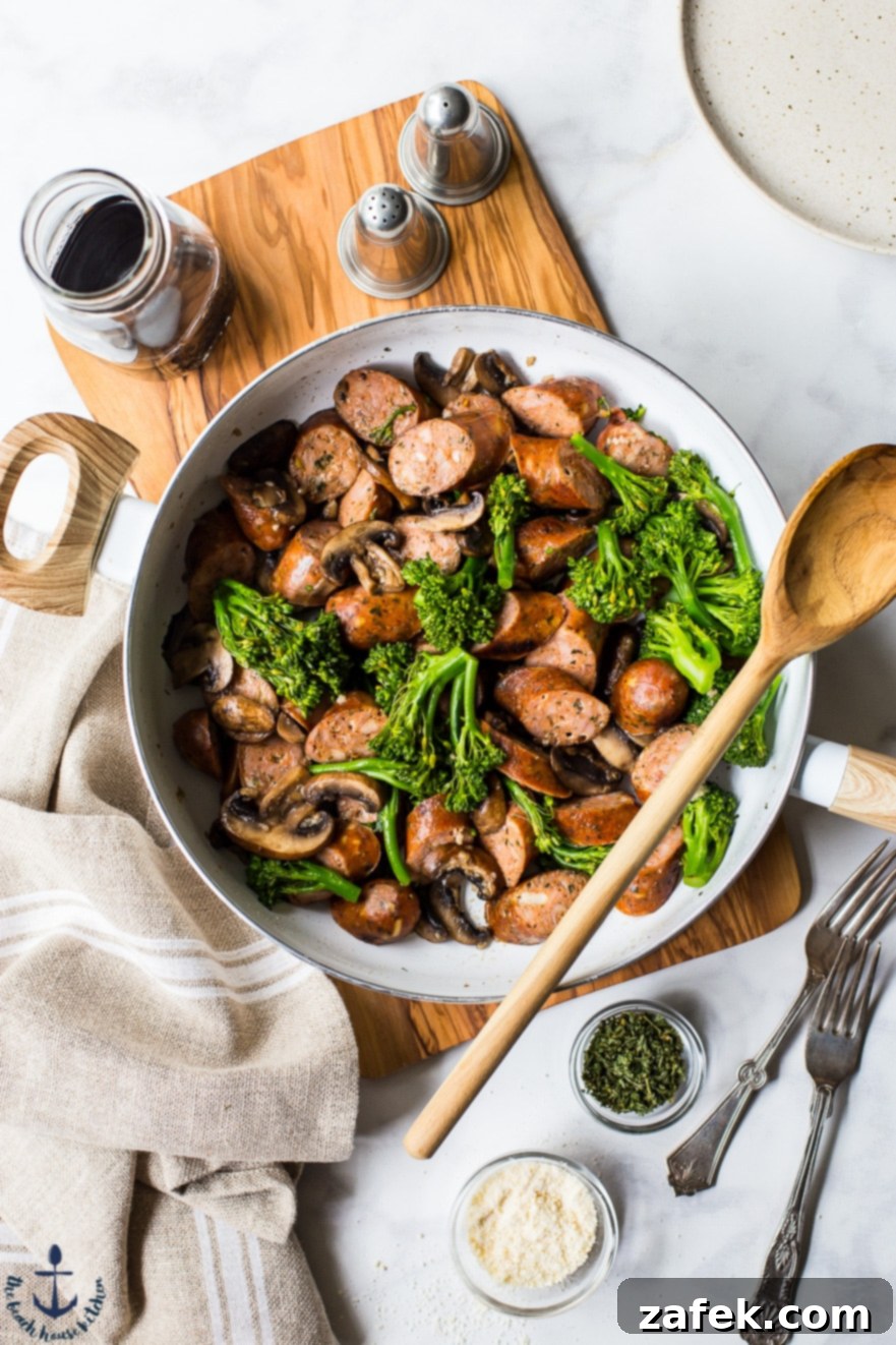 Overhead photo of a skillet with browned chicken sausage and tender broccoli florets, cooking together to meld flavors.
