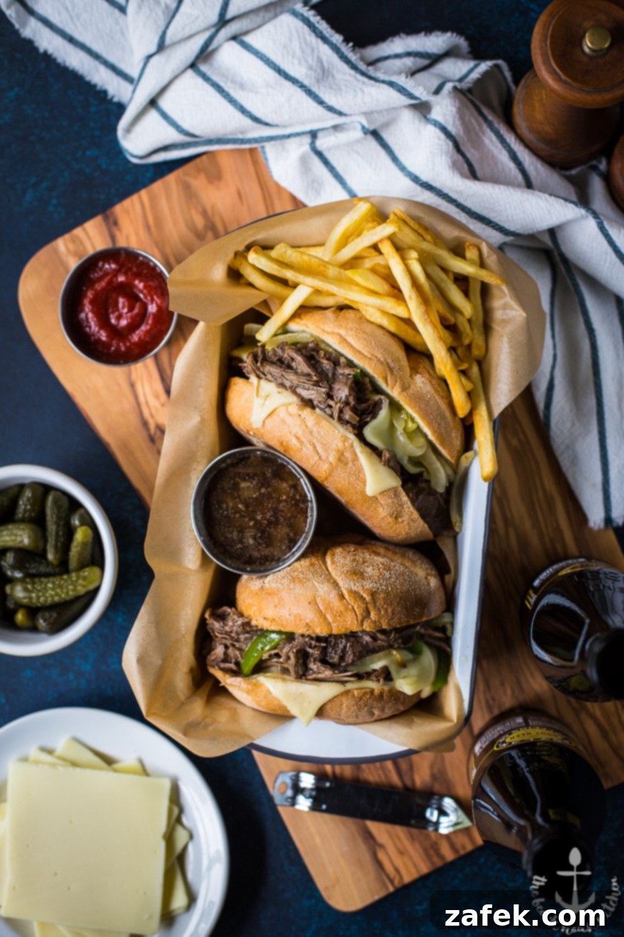 Philly French Dip Sandwiches with Peppers, Onions and Land O'Lakes Deli American Cheese Stacked Philly French Dip Sandwich with tender roast beef, melted Land O'Lakes Deli American cheese, caramelized onions and peppers, ready for dipping in au jus.