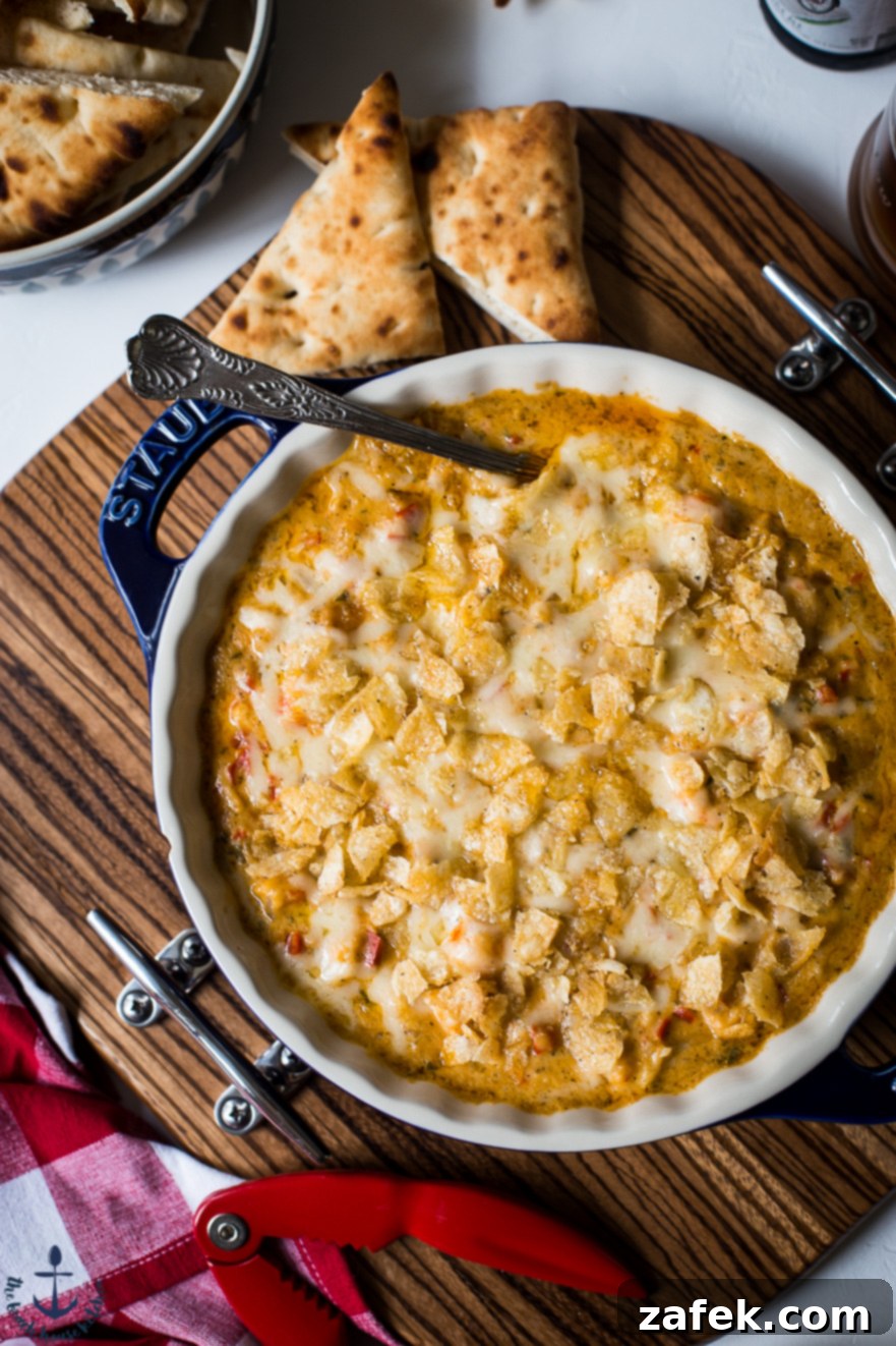 Hot Cheesy Lobster Dip garnished with fresh parsley and served with pita bread
