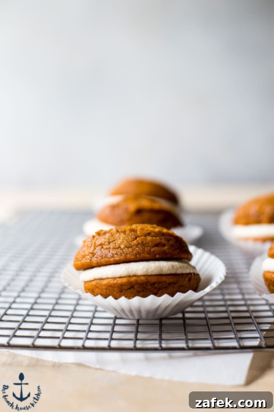 Pumpkin Whoopie Pies with Maple Buttercream A Pumpkin Whoopie Pie on a wire rack in a paper cupcake liner