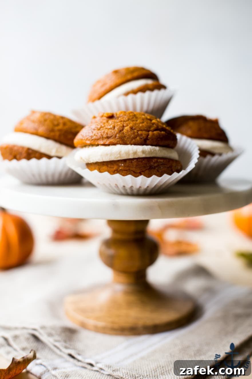 Pumpkin Whoopies Pies with Maple Buttercream Up close photo of a marble cake stand topped with whoopie pies