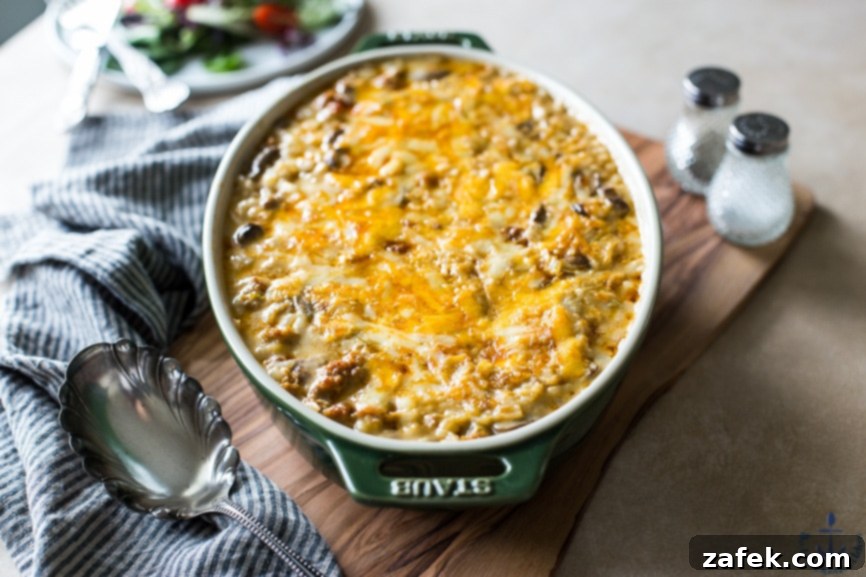 Close-up of baked sausage and rice, golden and bubbly with melted cheese
