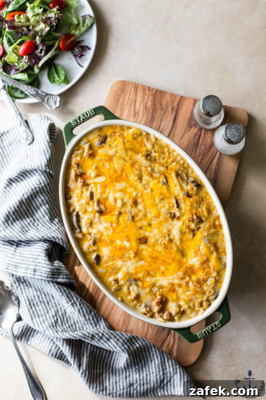 Overhead shot of Cheesy Spicy Sausage Rice Bake in a baking dish with a spoon, ready to serve