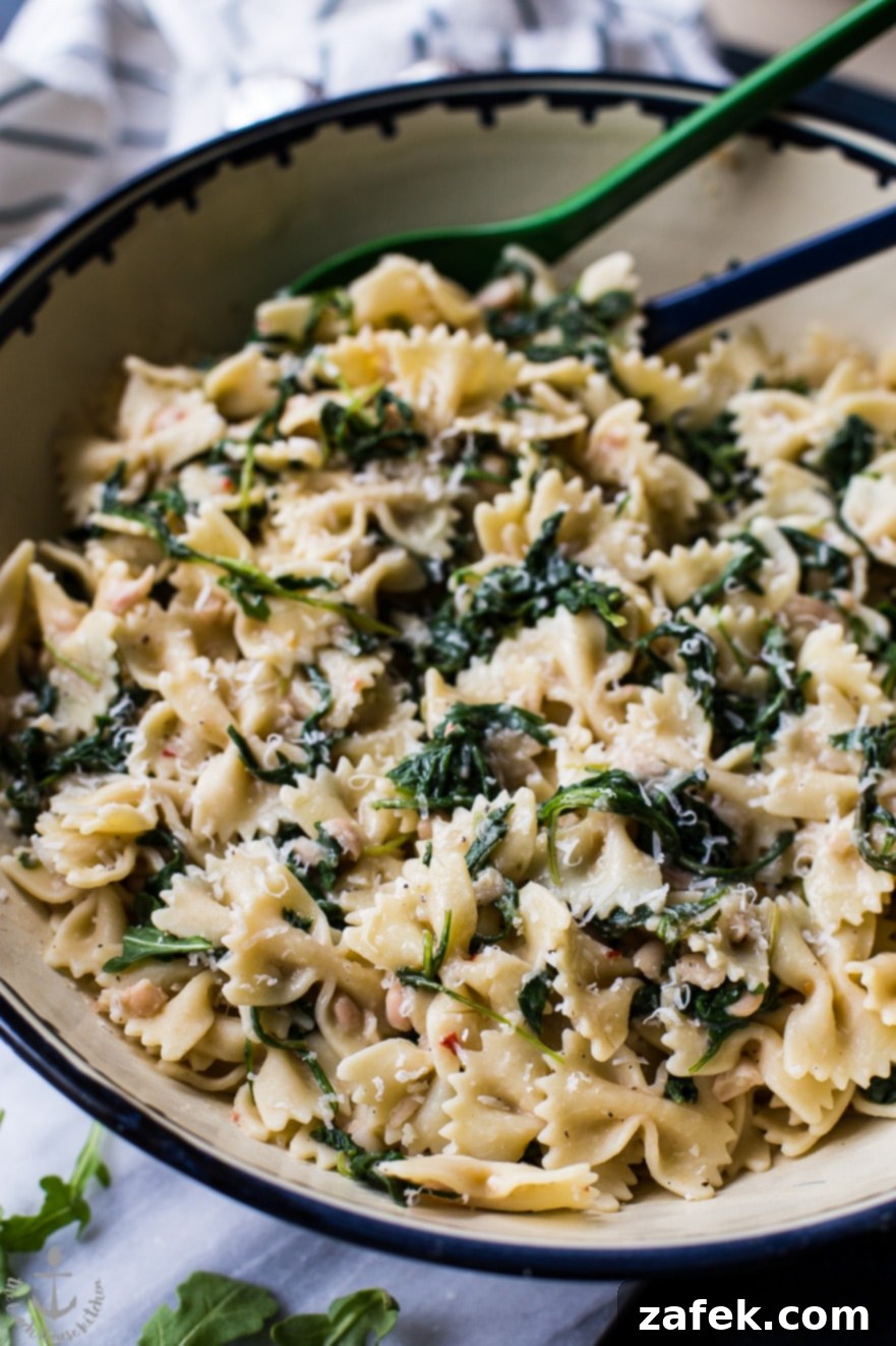 Bowl of Pasta with White Beans and Arugula with a fork