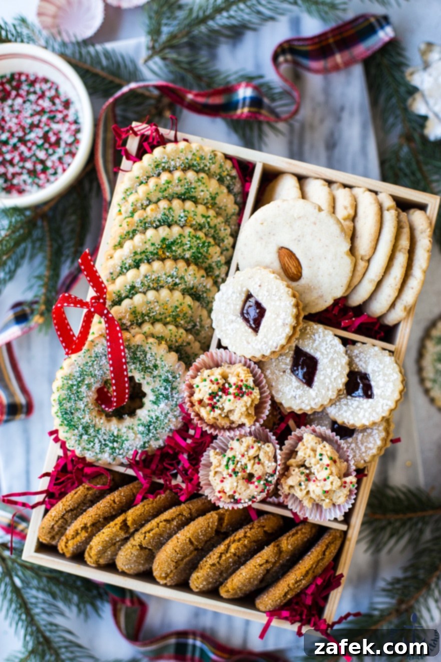 A top-down view of a beautifully packed holiday cookie gift box, showcasing a variety of festive baked goods.