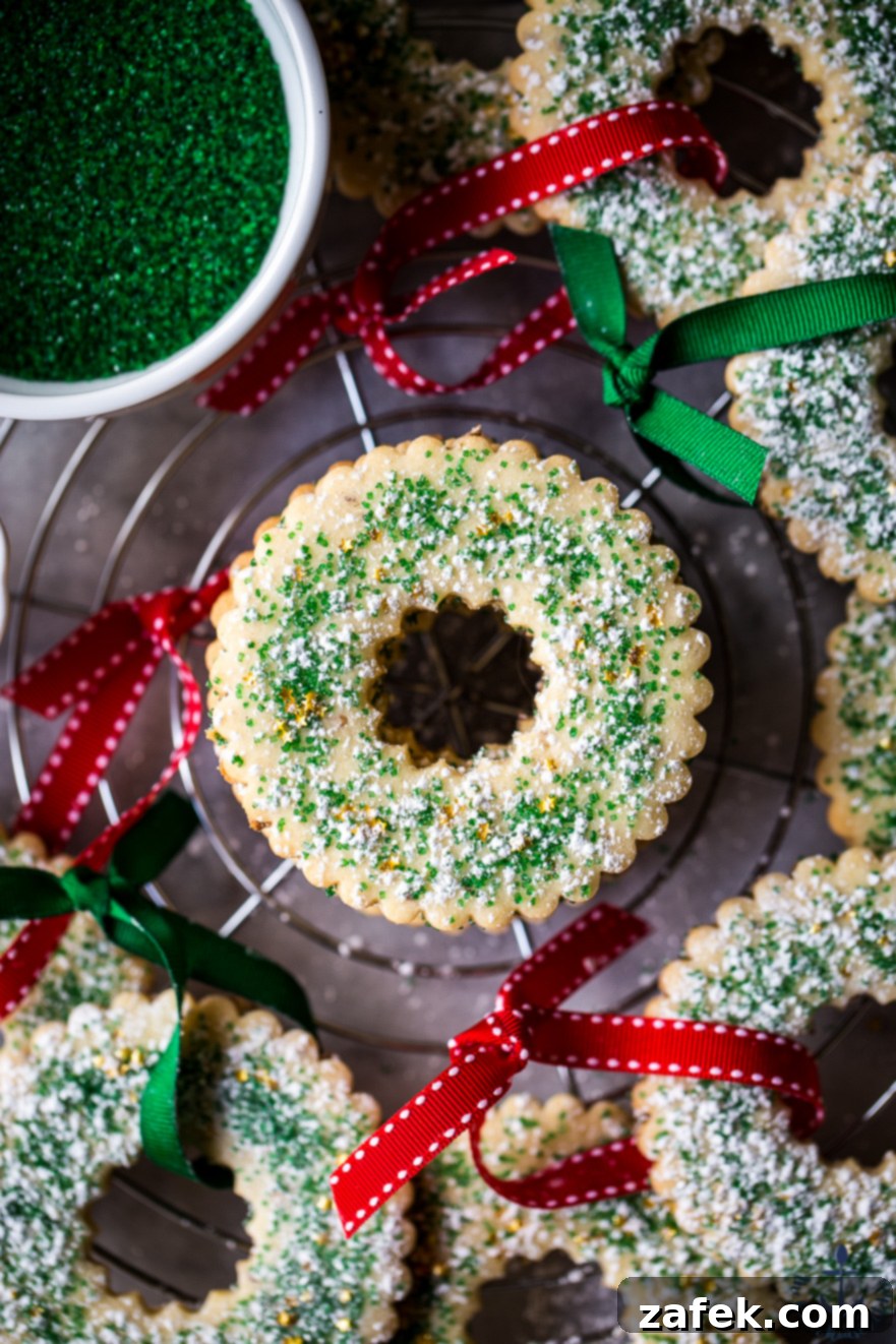 Classic round Anise Seed Sugar Cookies, lightly dusted with powdered sugar, offering a unique flavor to the holiday spread.