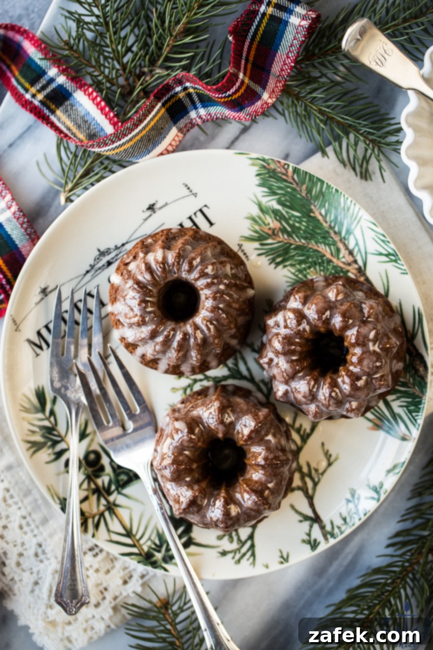 Close-up of Mini Gingerbread Bundt Cakes with Maple Glaze arranged on a rustic wooden surface