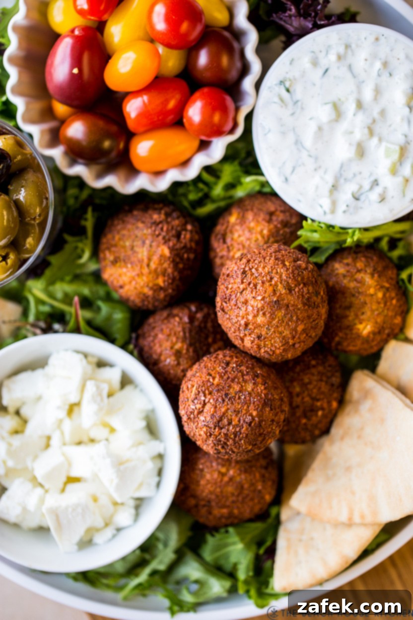 Super up close photo of falafel balls, feta, grape tomatoes and tzatziki sauce