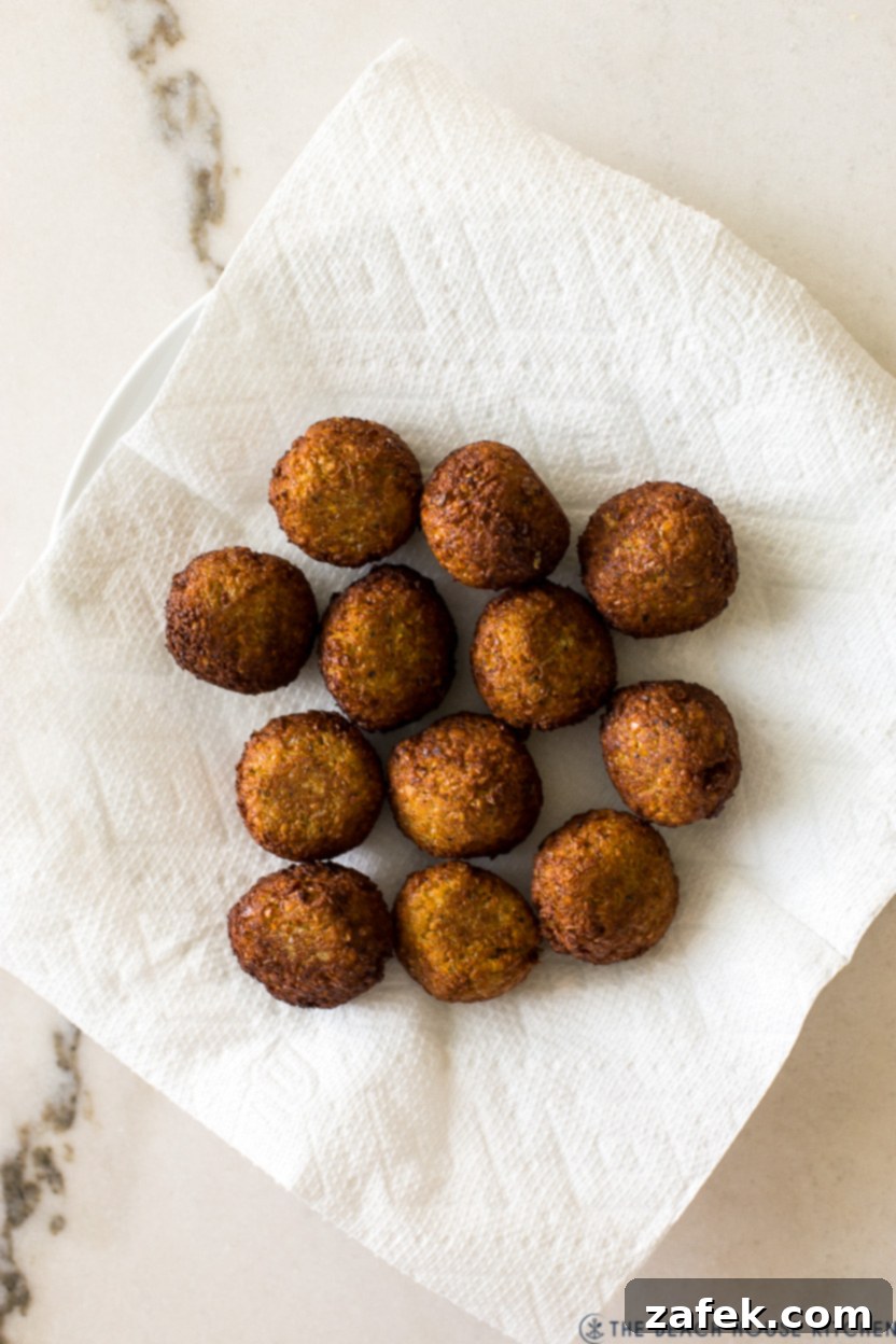 Overhead photo of falafel balls on a paper towel-lined plate