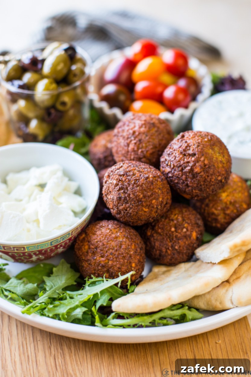 Up close photo of falafel balls on a platters with cheese and veggies