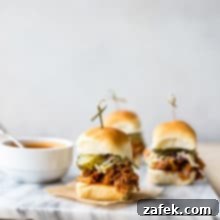 Sticky Sweet Heat Chicken Sliders 6 Close-up of a stack of Hot Honey Pulled Chicken Sliders on a marble board, showcasing the juicy chicken and glossy sauce