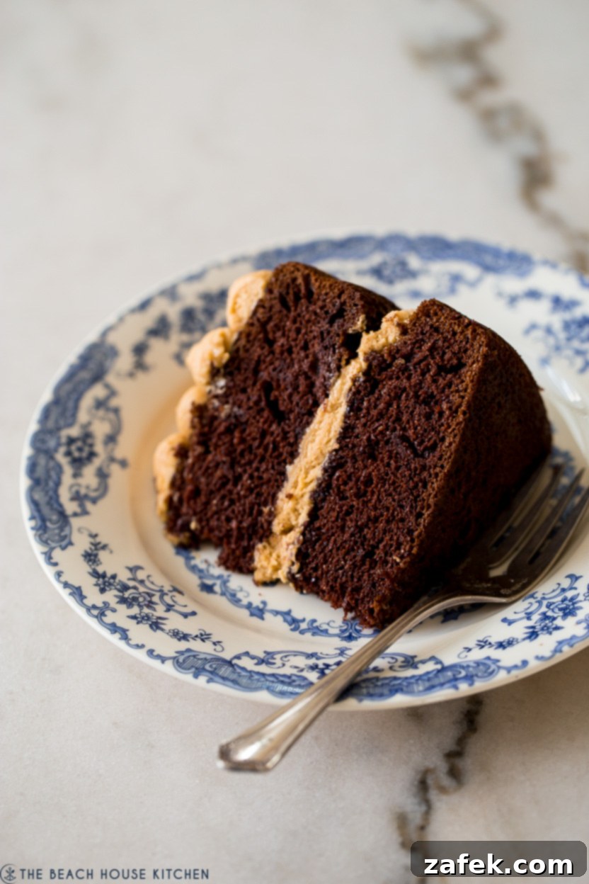 Up close photo of a piece of chocolate cake on a blue and white plate with a fork