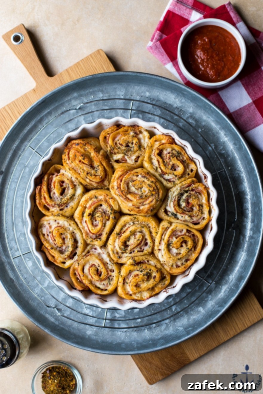 Overhead photo of sharp Italian pinwheels on a silver tray, perfectly golden brown