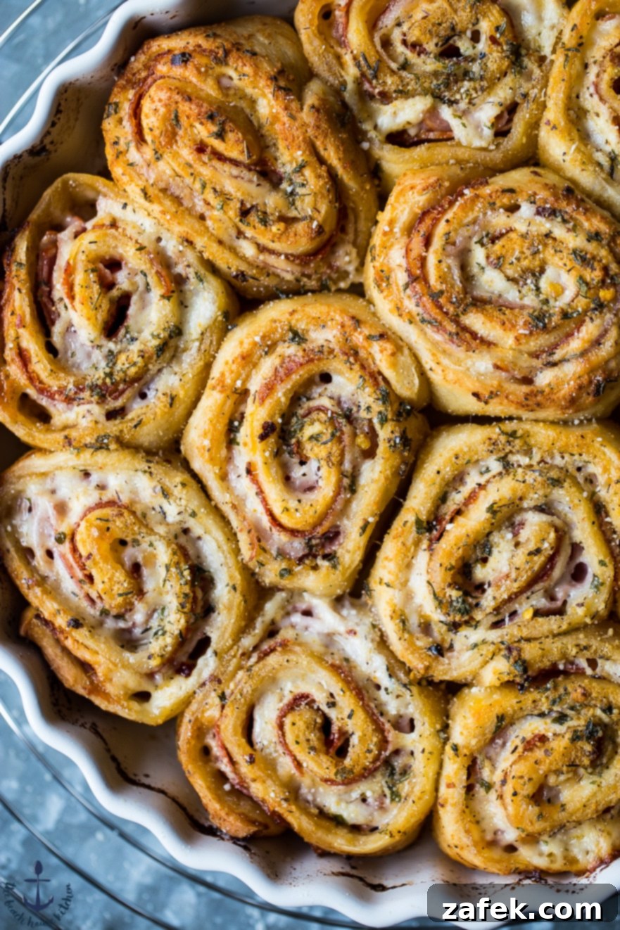 Overhead close up photo of freshly baked Sharp Italian Pinwheels, showcasing the layers of meat and cheese