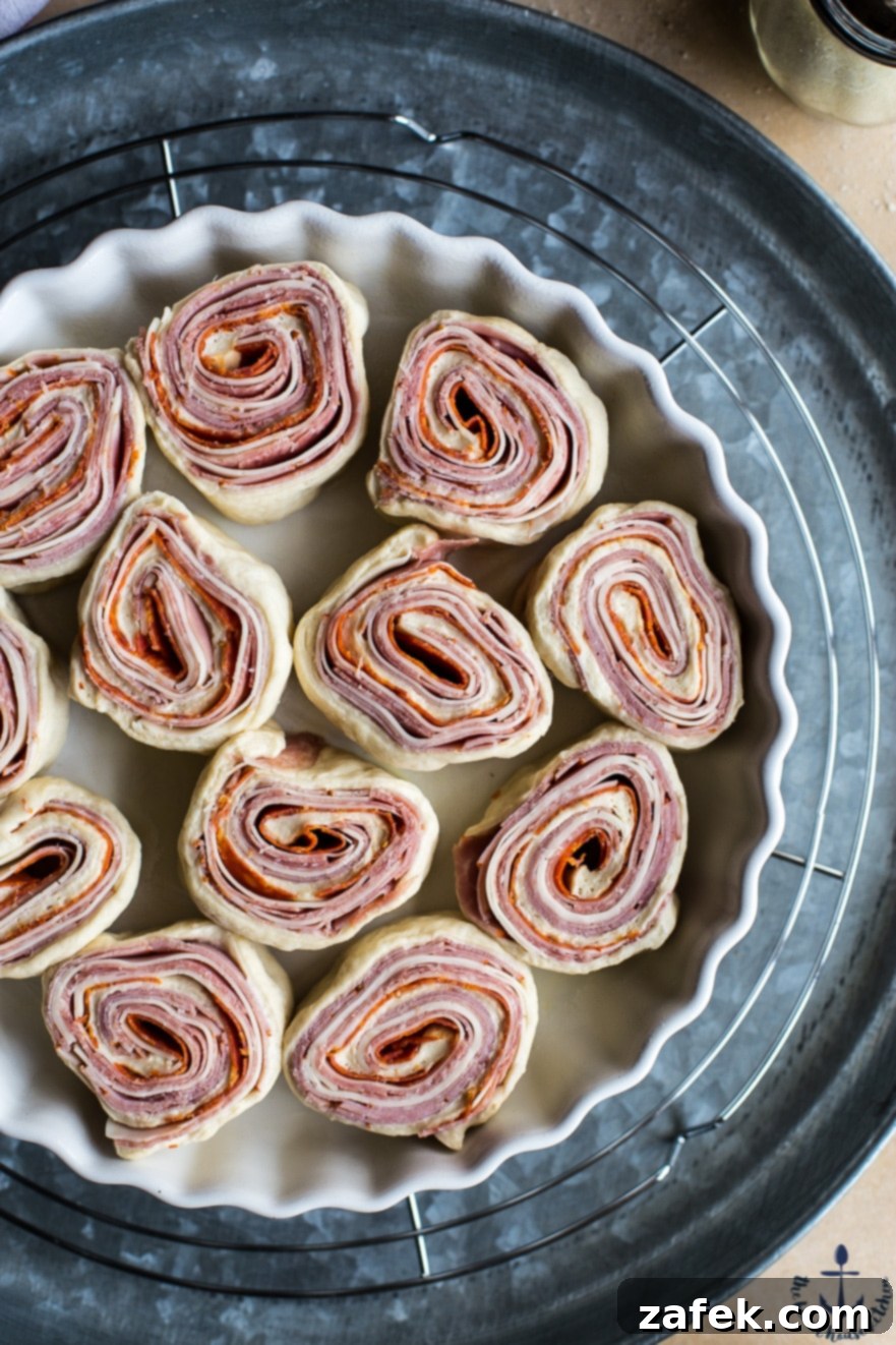 Overhead photo of pre-baked Sharp Italian Pinwheels arranged in a baking dish before going into the oven
