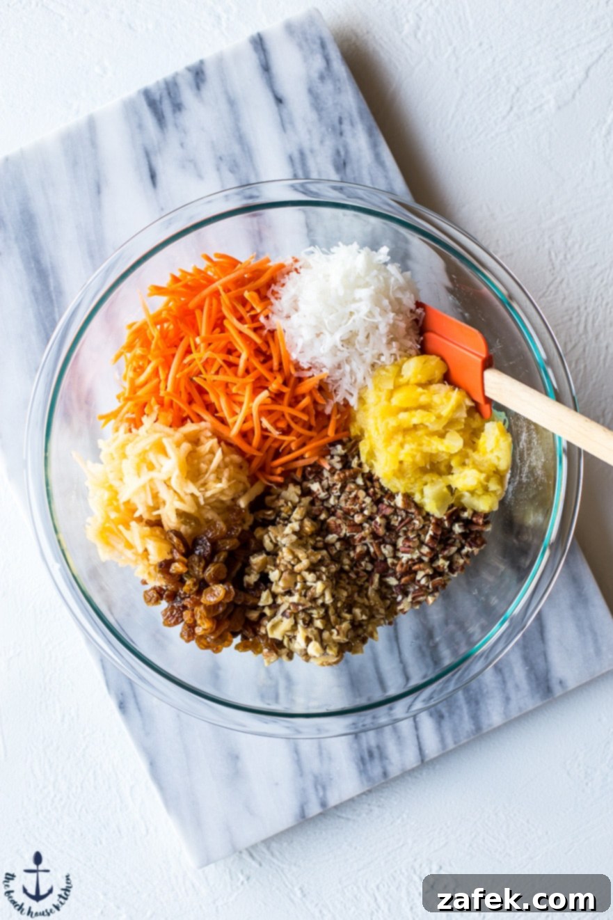 Sunrise Harvest Muffins 7 A glass bowl filled with the colorful mixed dry ingredients for Morning Glory Muffins, ready to be combined.