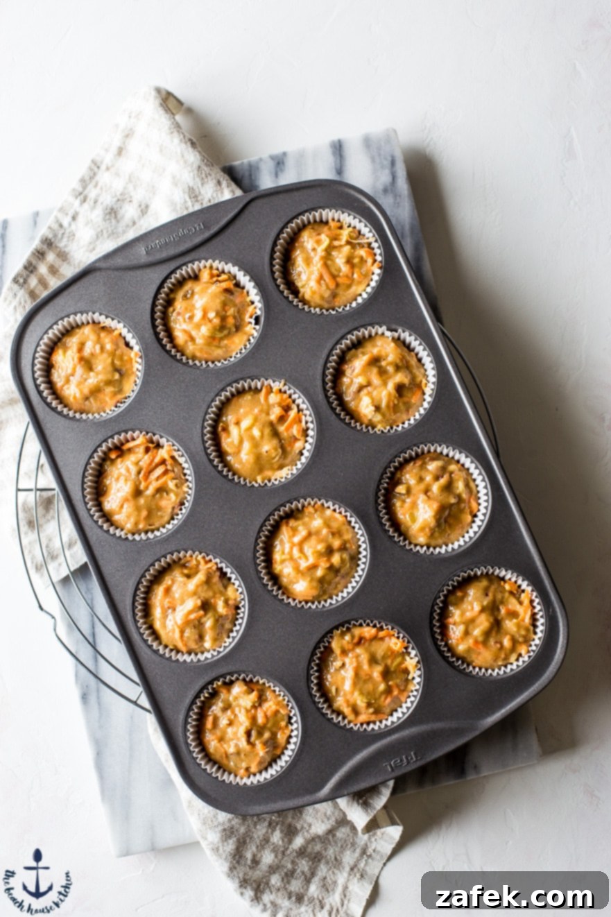 Sunrise Harvest Muffins 8 Overhead photo of unbaked Morning Glory Muffins batter in a muffin tin, showing the rich texture before baking.