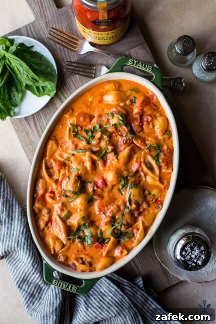 Overhead photo of an oval baking dish of Supreme Pizza Mac and Cheese, showcasing a golden-brown, bubbly top with melted cheese and pepperoni