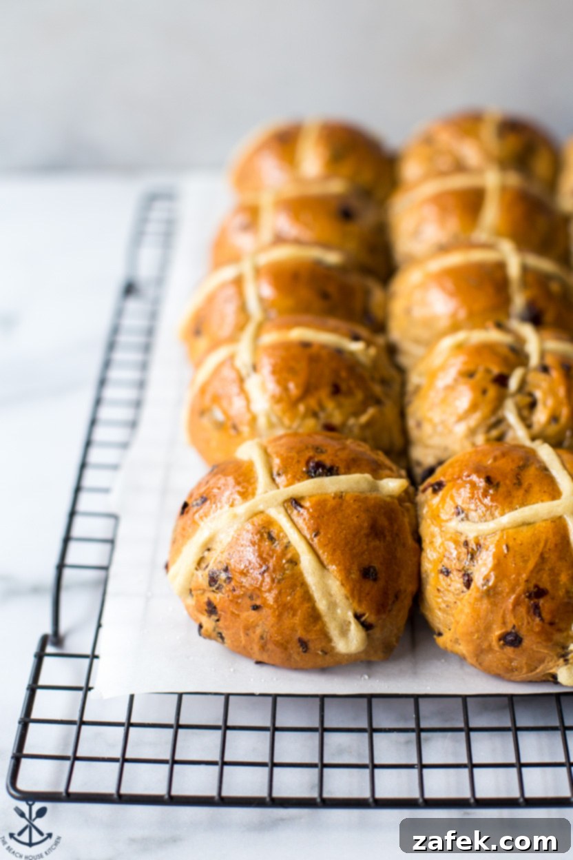 Spiced Easter Buns 3 A cluster of freshly baked Hot Cross Buns with their iconic white crosses, cooling on a black wire rack.