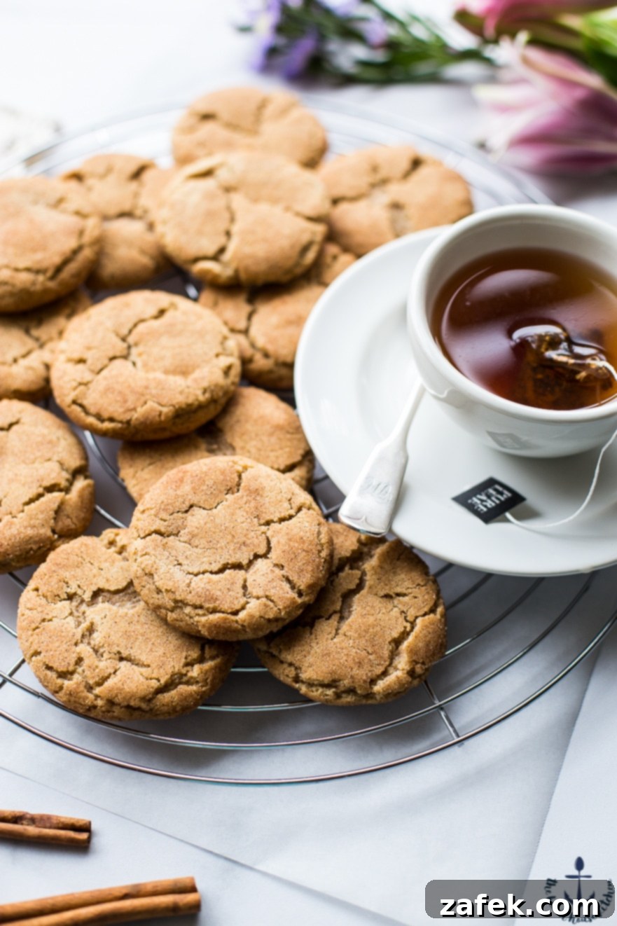 Warm Chai Spiced Snickerdoodle Cookies 4 A stack of three Chai Snickerdoodle Cookies on a wire rack, showcasing their perfectly round shape and spiced sugar coating, ready to be enjoyed.