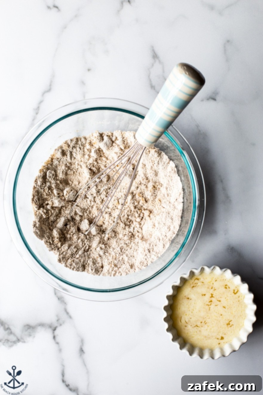 Overhead photo of a bowl filled with flour mixture and a small bowl filled with melted butter