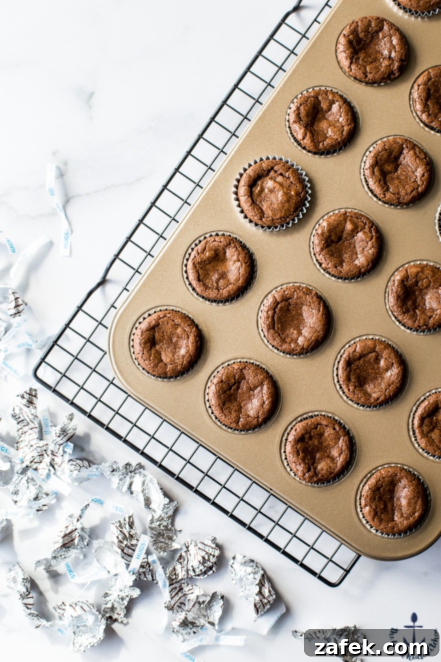 Hershey's Hug Brownie Bites Overhead photo of baked Hershey's Hug Brownie Bites cooling in a gold muffin pan, showcasing their perfectly set tops.