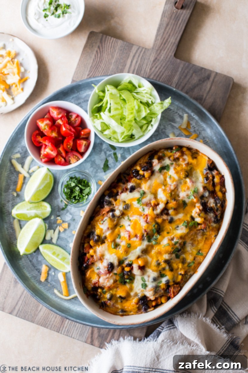 Southwestern Chicken Tortilla Bake 2 Overhead photo of a bubbling chicken black bean and tortilla casserole fresh from the oven, topped with melted cheese and fresh cilantro