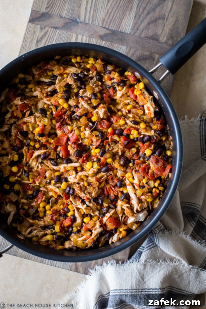 Southwestern Chicken Tortilla Bake 6 Overhead photo of a skillet filled with a vibrant mixture of tomatoes, corn, and black beans, simmering with spices