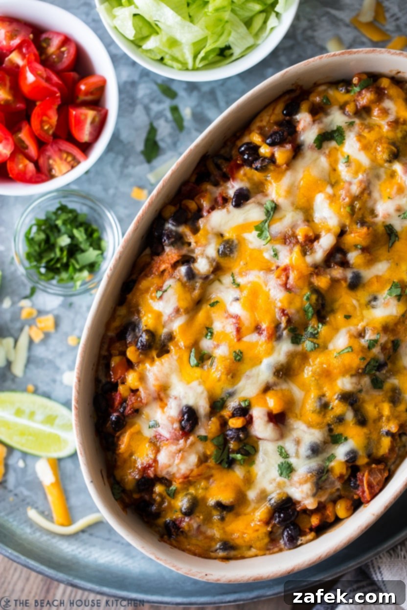 Southwestern Chicken Tortilla Bake 7 Up close overhead photo of a baked chicken black bean casserole, showing bubbly melted cheese and layered tortillas