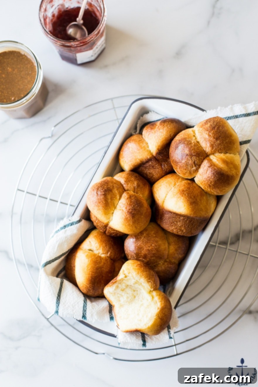 Puffy Brioche Buns 5 Warm Bubble-Top Brioche Rolls cooling on a wire rack, with a view of their rich, golden crust.