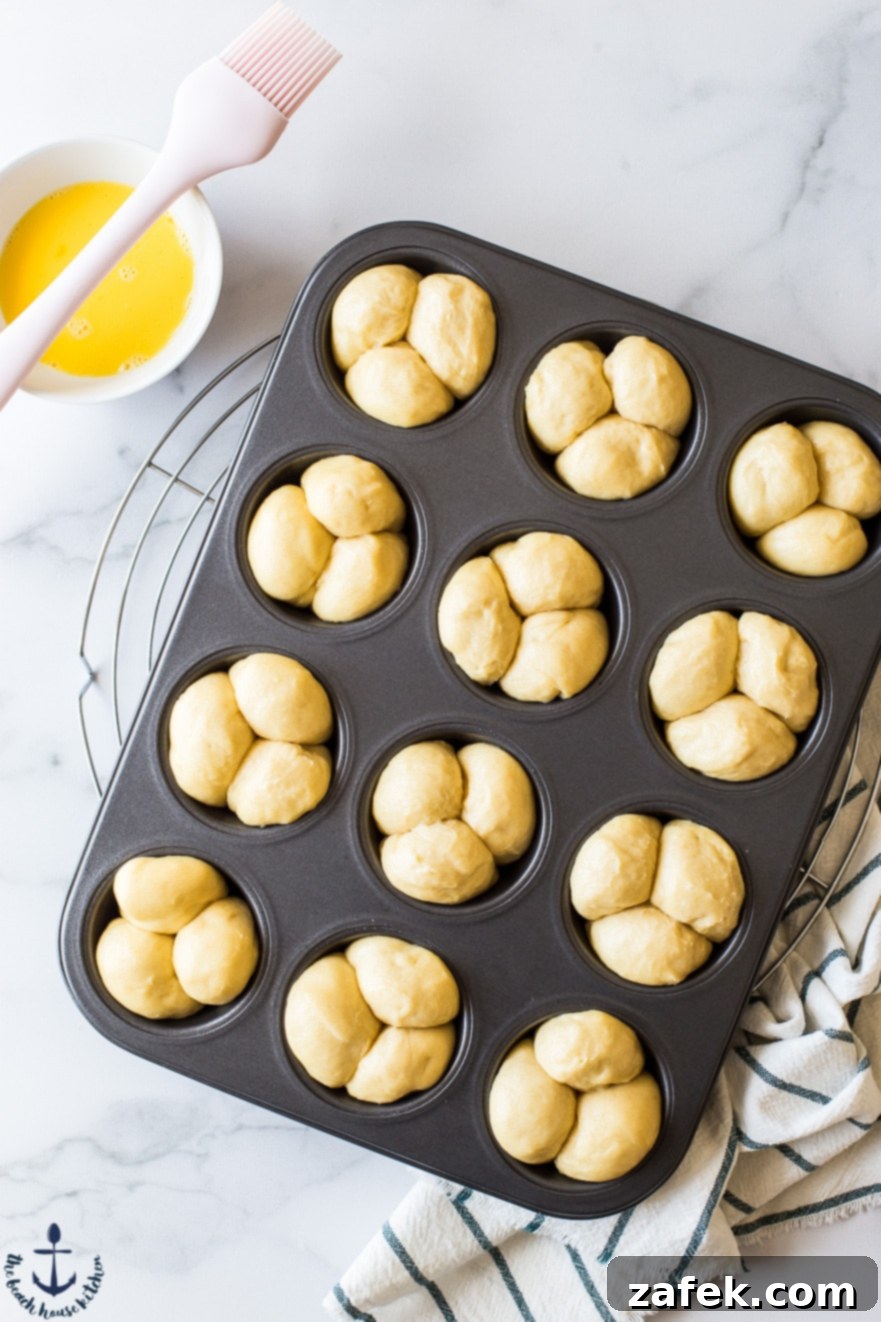 Puffy Brioche Buns 6 Unbaked Bubble-Top Brioche Roll dough, shaped into small balls and rising in a muffin pan.