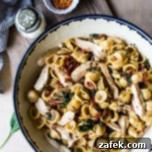 Tuscan Chicken Pasta with Sun-Dried Tomato Bacon Cream 5 Chicken Pasta with Sun-Dried Tomato Bacon Cream Sauce in a bowl on a wooden board