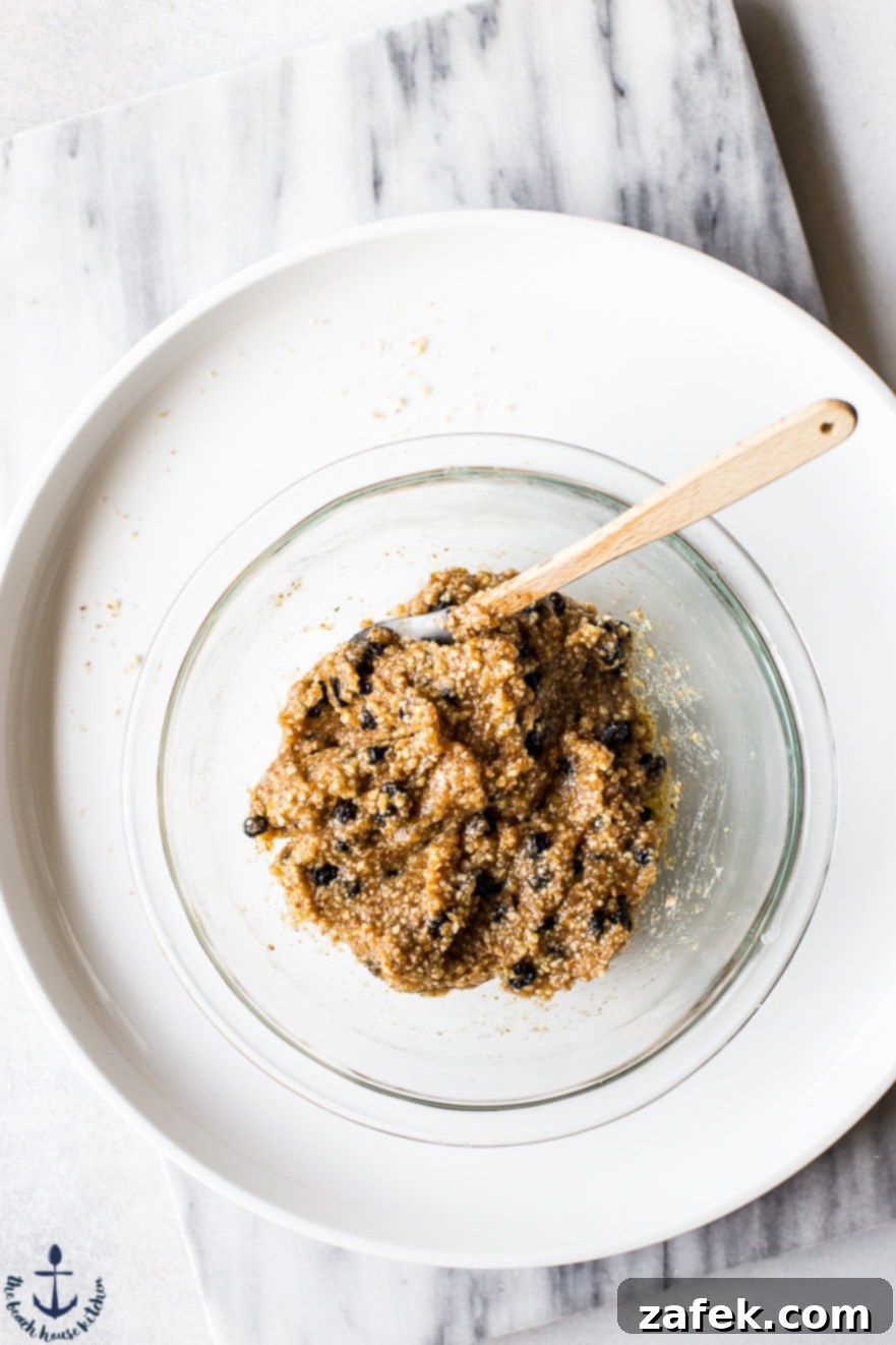 Clear mixing bowl holding the mixed dough for blueberry lemon breakfast bites, showing its moist and crumbly texture before rolling.