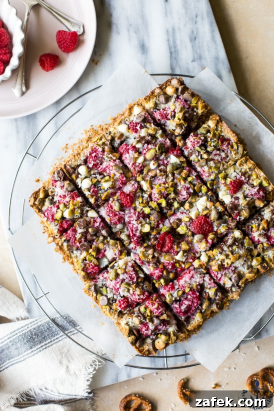 Overhead photo of a baking pan filled with freshly cut Raspberry Pistachio Magic Bars, showing their ready-to-serve appeal and delicious layers.
