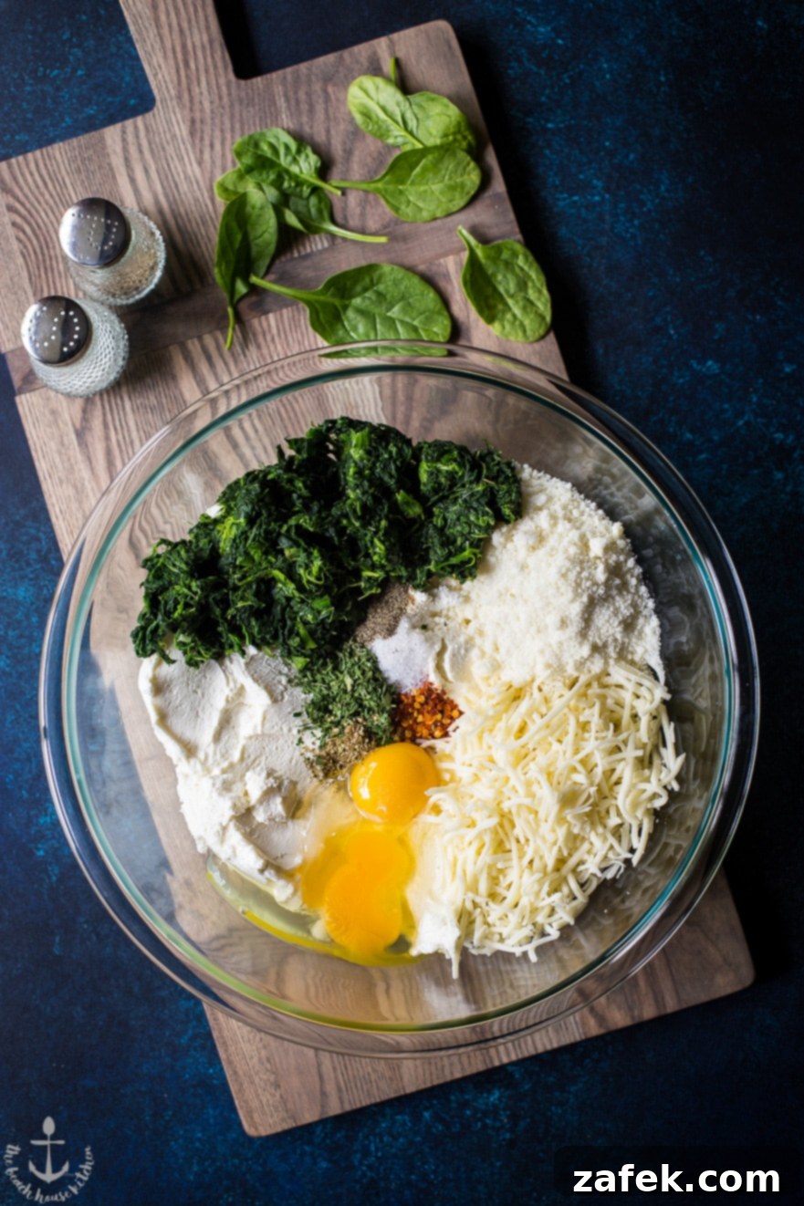 Overhead photo of filling ingredients for easy spinach stuffed shells in a clear bowl on a wooden board