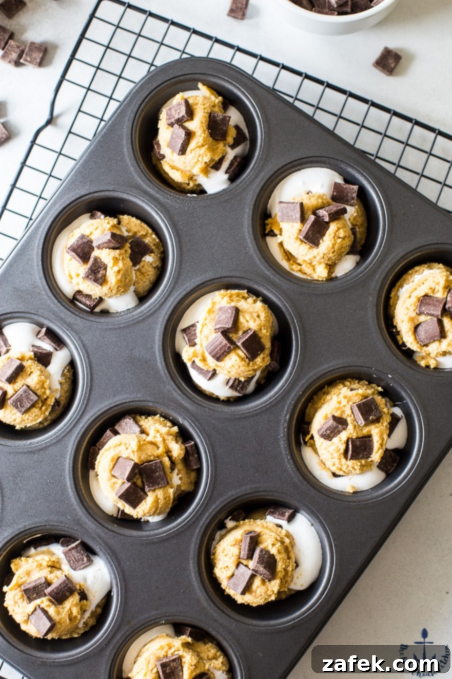 Overhead photo of a single S'mores Cup batter portion in a muffin tin, ready for fluff