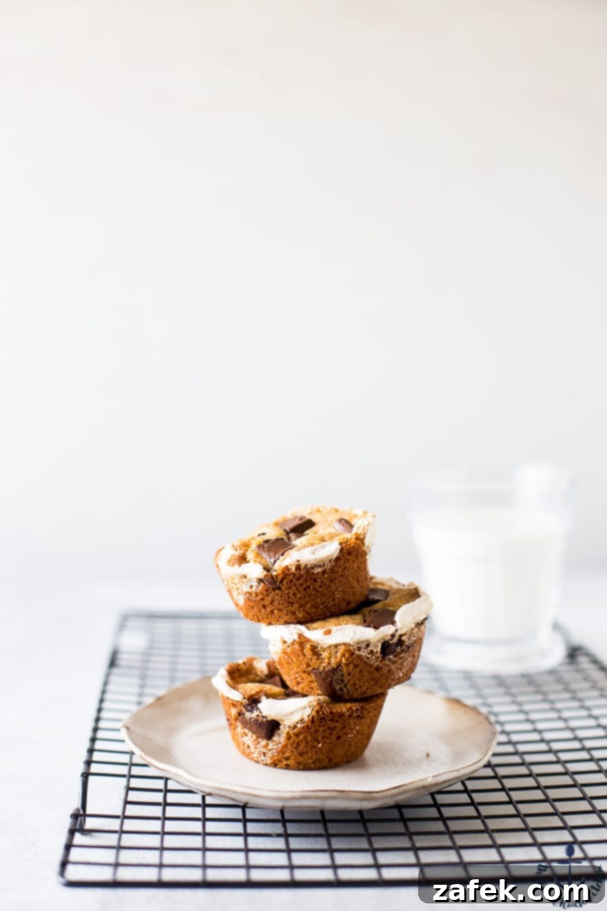 Stack of S'mores Cups on a plate with one cut open to show the gooey interior