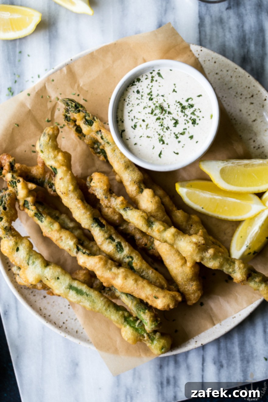 Overhead photo of asparagus tempura on a plate with horseradish cream sauce