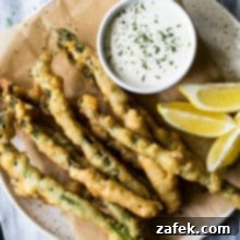 Overhead photo of asparagus tempura on a plate with horseradish cream sauce