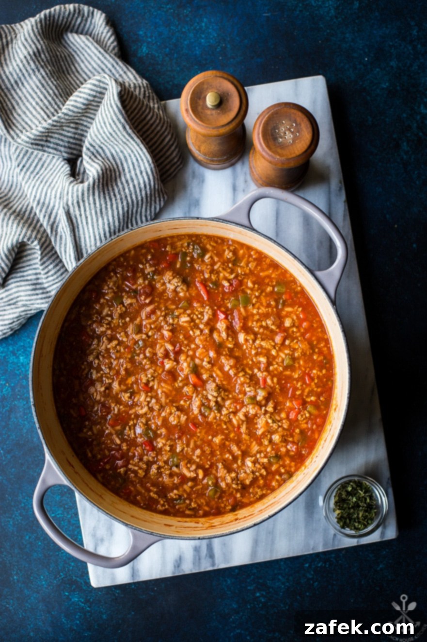 Overhead photo of pot filled with stuffed pepper soup on a marble board