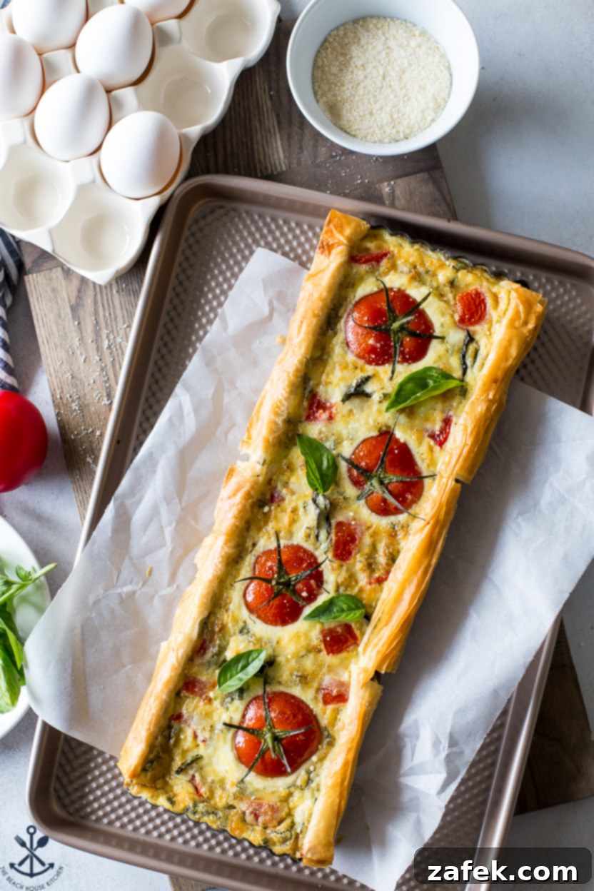 A beautifully baked Tomato Basil Tart with fresh basil leaves for garnish.